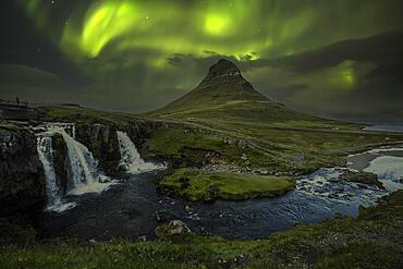 Kirkjufellsfoss landscape at night with a beautiful Northern Lights. Iceland