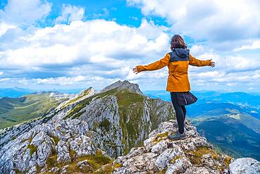 Mount Aizkorri 1523 meters, the highest in Guipuzcoa. Basque Country. Ascent through San Adrian and return through the Oltza fields. A young woman in yellow looking at the views on top