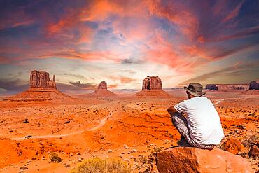 A young man in a white t-shirt in Monument Valley National Park at the visitor center at sunset, Utah. United States