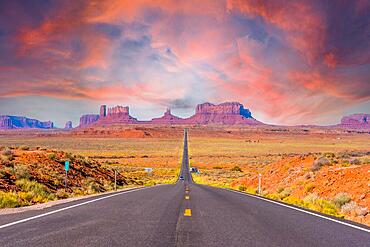 Highway reaching Monument Valley at sunset, Utah. United States