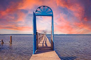 A blue door in the Caribbean Sea on the island of Roatan at sunset. Honduras