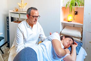 Women lying on stretcher receiving a relief massage in a Qi gong masseur clinic