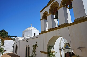 Cross-domed church Diasososuan, White church with a bell tower and several arches, blue sky in the background, plants hanging from the walls, Chora, Old Town, Patmos, Dodecanese, Greek Islands, Greece, Europe