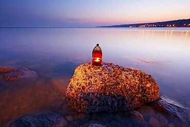 Sunset on the rocky coast with red lantern