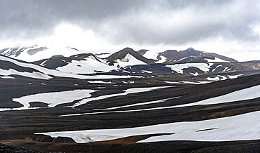 Dramatic volcanic landscape with mountains and snow, at Höskuldsskáli hut in Hrafntinnusker, Laugavegur trekking trail, Landmannalaugar, Fjallabak Nature Reserve, Suðurland, Iceland, Europe