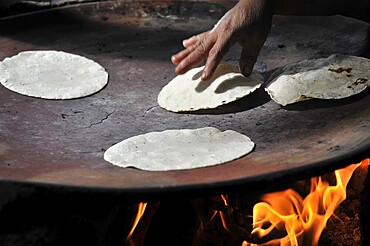 Mitla, Oaxaca, Mexico, Central America, Tortillas are baked on an open fire, a hand turns the tortillas, Central America