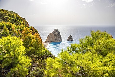 Viewpoint with a view of a landscape on a coast with Mediterranean flair. Taken in the morning light with sun and haze over the sea. the Myzithres Rock, Ionian Island of Zakynthos, Greece, Europe