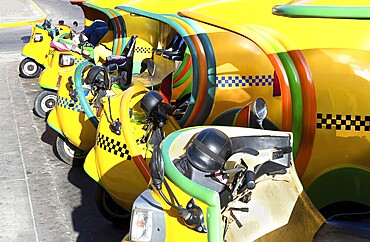 Famous colorful Coco Taxis in Havana waiting for tourists to take a ride in a vintage car around major city attractions