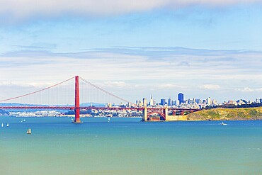 Distant telephoto landscape view over ocean water through Golden Gate Bridge to San Francisco Cityscape under a beautiful sunny, blue sky. Copy space