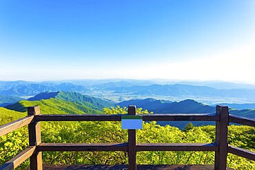 Wooden viewpoint deck offering clear view of valley below from atop Jirisan Mountain in South Korea. Horizontal