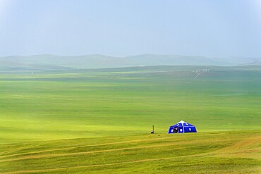 A lone purple yurt stands in the vast Mongolian steppe in rural Mongolia