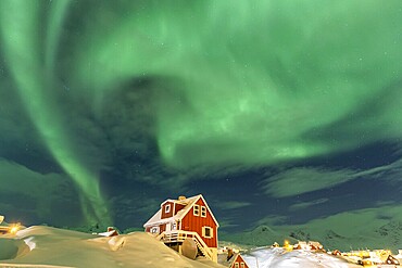 Northern Lights, Aurora borealis over red house, Inuit settlement, Winter, Tasiilaq, East Greenland, Greenland, North America