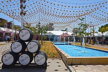 Colourful fairy lights over barrels next to a water basin, festive atmosphere, Feria de la Manzanilla, Feria de Sanlúcar, Sanlúcar de Barrameda, Sanlucar, Province of Cádiz, Cadiz, Andalusia, Spain, Europe