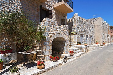 Charming stone alley with flowers in a sunny village, Geromilenas, Mani, Laconia, Peloponnese, Greece, Europe