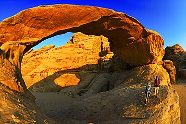 Couple hiking at Rock-Arch Al Kharza, Wadi Rum, Jordan, Asia