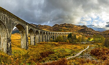Glenfinnan railway viaduct, with autumn colours and cloudy sky, Glenfinnan, West Highlands, Scotland, Great Britain