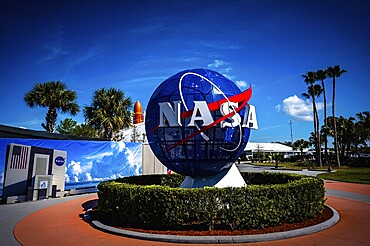NASA logo with globe in front of blue sky and palm trees at the Kennedy Space Center, Cape Canaveral