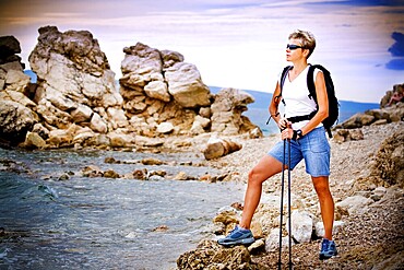 Woman hiking along the sea shore
