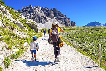 Tourists walking on a sunny summer day on the trail around tre cime di lavaredo in the dolomites