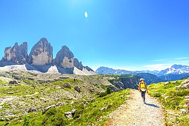Tourist walking on a mountain path near tre cime di lavaredo, a symbol of the dolomites, a unesco world heritage site