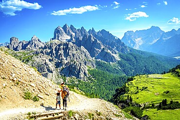 Tourists enjoying breathtaking views while hiking on a scenic trail in tre cime di lavaredo, dolomites, italy, during a sunny summer day