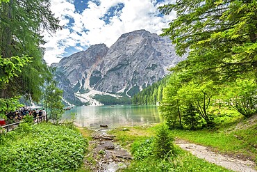 Tourists enjoying the landscape at lake braies, also called pragser wildsee, with the seekofel mountain in the background, in the dolomites, south tyrol, italy