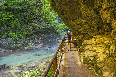 Tourists walking along the radovna river in vintgar gorge, near bled, slovenia, enjoying the stunning scenery and peaceful surroundings