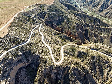Canyons and gorges near village Gorafe, winding road, aerial view, Gorafe Desert, UNESCO Granada Geopark, Granada province, Andalusia, Spain, Europe