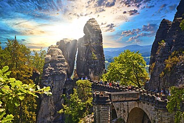 Stone Bastei Bridge connects imposing rocks at sunset, surrounded by lush trees, Elbe Sandstone Mountains, Saxon Switzerland, Saxony, Germany, Europe
