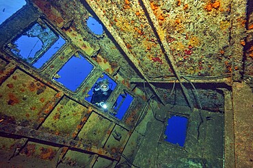 Diver looking through window opening into the interior of a shipwreck, Tenerife, Canary Islands, Spain, Europe