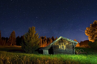Wooden barn under a nigth sky full of stars