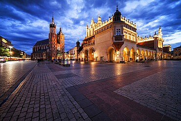 Krakow city in the evening in Poland, Main Square in the Old Town, illuminated St. Mary Church and Cloth Hall (Sukiennice)