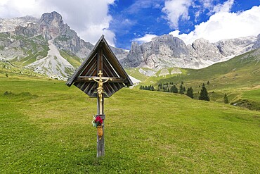 Crucifix in the meadows of Fuciade Valley in the Dolomites