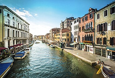 Ancient buildings and boats in the channel in Venice