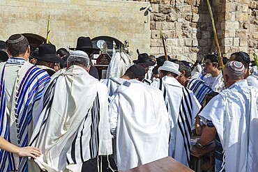JERUSALEM, ISRAEL - OCTOBER 12, 2014: Morning autumn Sukkot. The area in front of Western Wall of Temple filled with people. Crowd of faithful Jews wearing prayer shawls