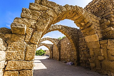 Picturesque ruins of the ancient city of Caesarea. Israel. Sunny spring day. Arched passage - covered street of Port of Caesarea. Concept of ecological and historical tourism