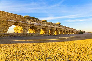 High aqueduct, built under the reign of Herod the Great. Concept of active, ecological and historical tourism. Fantastic sunset on the Mediterranean coast in Caesarea
