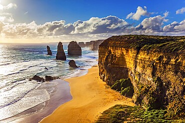 Powerful Pacific surf breaks down on the shore. Grandiose coast of Australia. Rocks of the Twelve Apostles at sunset. The concept of exotic, active and photo-tourism