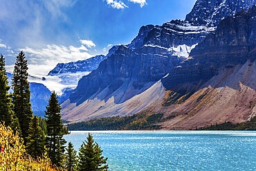 The Rockies of Canada. The picturesque huge and deep Lake Bow is surrounded by cliffs and glaciers. The wind drives lush cumulus clouds. The concept of active and photo tourism