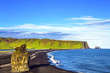 Cape Dyrholaey. The southern edge of Iceland. Beach with black volcanic ash Reinisfjara. Giant lonely rock - Palm on a black volcanic sand beach
