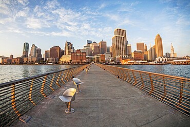 San Francisco cityscape with Ferry Terminal at sunrise from Pier 14 with metal swivel chairs, distorted fish eye perspective from Pier 14