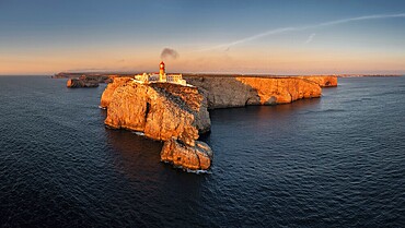 Portuguese coast with a lighthouse in the rays of the setting sun, Cabo De Sao Vincente on sunset