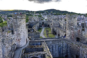 Conwy Castle, medieval castle with towers and surrounding town in a green landscape under a cloudy sky, Conwy, Wales, Great Britain