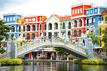 A curved bridge over water with colorful European-style buildings in the background, Grand World Phu Quoc, Vietnam, Asia