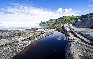 Reflection in a tidal pool, rocky coast of Tungeneset, Devil's Teeth, Okshornan, Ersfjorden, Senja Island, Troms, Norway, Europe