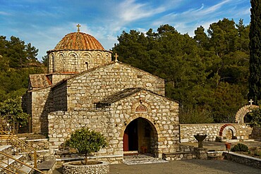 Historic stone church under a blue sky surrounded by trees, Thari Monastery, Moni Thari, near Gadouras Reservoir, lonely mountain region, Rhodes, Dodecanese, Greek Islands, Greece, Europe