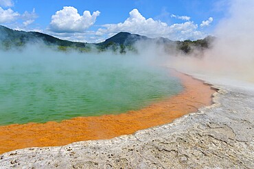 Bubbling mineral spring with steam and surrounded by mountains, Champagne Pool thermal lake, Wai-O-Tapu Thermal Wonderland, Rotorua, North Island, New Zealand, Oceania