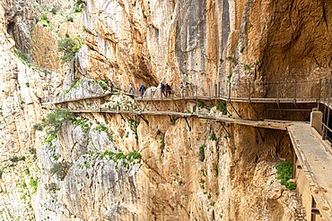 People walking on the narrow Caminito del Rey path that runs along a dramatic cliff face, Malaga, Spain, Europe