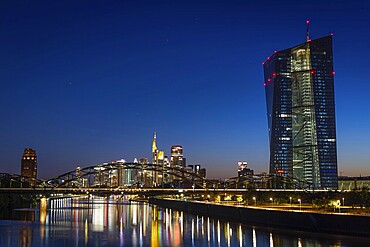 The European Central Bank (ECB) and the Frankfurt banking skyline are reflected in the calm waters of the Main at blue hour, Osthafen, Frankfurt am Main, Hesse, Germany