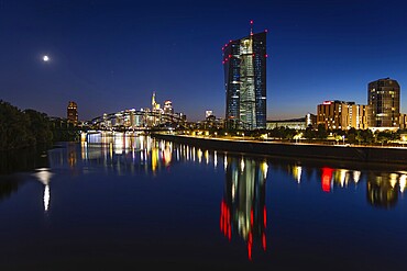 The European Central Bank (ECB) and the Frankfurt banking skyline are reflected in the calm waters of the Main at blue hour, Osthafen, Frankfurt am Main, Hesse, Germany